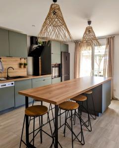 a kitchen with a wooden table and stools at KiWi in Canet-en-Roussillon