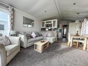 a living room with a couch and a table at Wonderful 6 Berth Caravan For Hire By A Stunning Norfolk Beach Ref 19006sd in Scratby