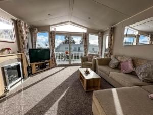 a living room with a couch and a tv at Wonderful 6 Berth Caravan For Hire By A Stunning Norfolk Beach Ref 19006sd in Scratby