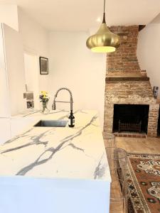 a kitchen with a sink and a fireplace at Close to Goodwood- Dogs Welcome -3 beds & Parking in Petworth