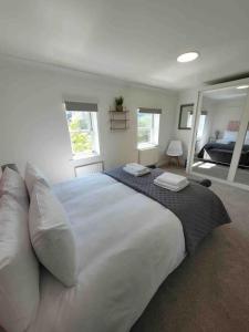 a bedroom with a large white bed with pillows at 5 Bed Modern Cheltenham Town Centre Home in Cheltenham