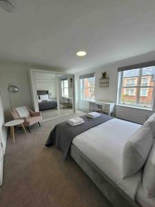 a large bedroom with a large bed and a couch at 5 Bed Modern Cheltenham Town Centre Home in Cheltenham