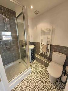 a bathroom with a shower and a toilet and a sink at 5 Bed Modern Cheltenham Town Centre Home in Cheltenham