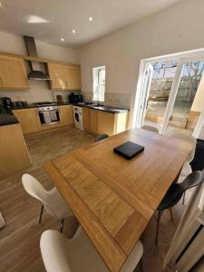 a kitchen with a wooden table and some chairs at 5 Bed Modern Cheltenham Town Centre Home in Cheltenham