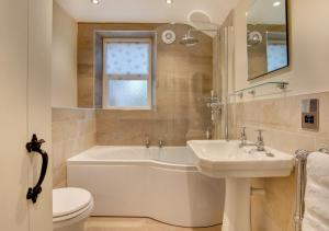uma casa de banho com uma banheira, um lavatório e um WC. em Monks Bridge em Crosby Ravensworth