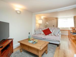 a living room with a couch and a table at Otters Cottage in Ottery Saint Mary