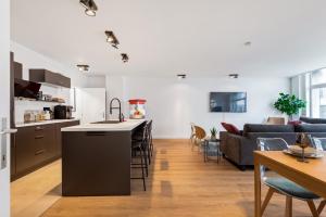 a kitchen and living room with a couch and a table at Cozy Antwerp - City Family Apartment with Parking in Antwerp