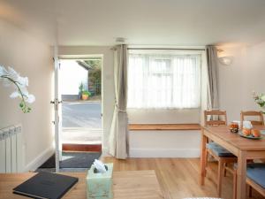 een woonkamer met een tafel en een raam bij Otters Cottage in Ottery Saint Mary