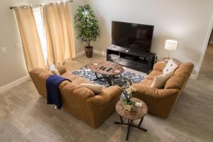 a living room with two couches and a tv at Gated Community!! Sparkling Private Pool, Near Disney in Kissimmee