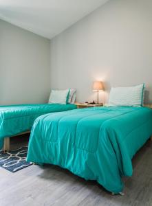 dwa łóżka z zieloną pościelą w pokoju w obiekcie Gated Community!! Sparkling Private Pool, Near Disney w mieście Kissimmee