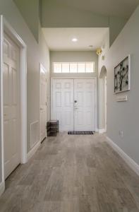 a hallway with white doors and wood floors at Gated Community!! Sparkling Private Pool, Near Disney in Kissimmee
