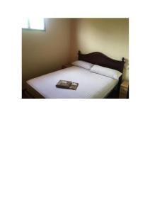 uma foto de uma cama com um livro sobre ela em Cortijo de Lorente Alojamiento Turístico Rural -Teba -Malaga em Teba
