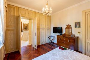um quarto com uma cama, uma televisão e uma cómoda em Villa Liberty a soli 20km da Venezia em Mira
