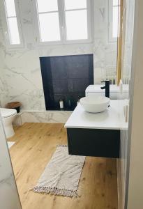 ein Badezimmer mit einer weißen Theke und einem Waschbecken in der Unterkunft Appartement plein centre ville d’Alfortville in Alfortville