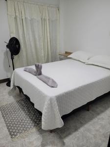 ein Schlafzimmer mit einem weißen Bett mit einem Kleid darauf in der Unterkunft Casa Central, primer piso in Norcasia