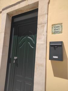 Una puerta verde en un edificio con un buzón. en Casa Ciuri Ciuri, en Noto
