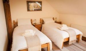 Dos camas en una habitación con sábanas blancas. en Bradstones, en Wirksworth 7 fotos más