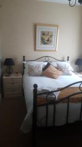 a bedroom with a bed with white sheets and pillows at Billys in Kedington