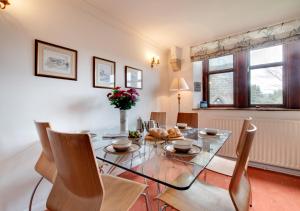a dining room with a glass table and chairs at Humbug Lodge in Pateley Bridge