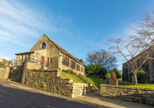 an old stone building on the side of a street at Humbug Lodge in Pateley Bridge