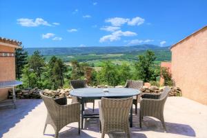 a table and chairs on a patio with a view at Domaine du Val de Sault in Sault-de-Vaucluse