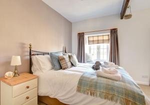 a bedroom with a bed with a teddy bear on it at Wren Cottage in Middleham