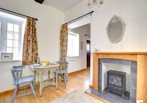 a living room with a table and a fireplace at Wren Cottage in Middleham