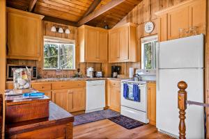 a kitchen with wooden cabinets and a white refrigerator at Cambria Escape in Cambria