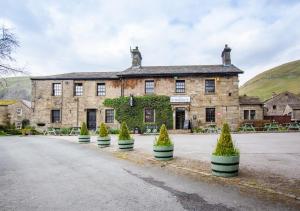 an old stone building with plants inront of it at Mullions Nook in Buckden