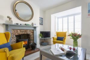 a living room with yellow chairs and a fireplace at Start Way in Kingsbridge