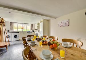a kitchen and dining room with a wooden table and chairs at Wagtail Cottage in Tosside