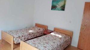 a room with two beds and a picture on the wall at Guest House - Apartment Kozle in Skopje