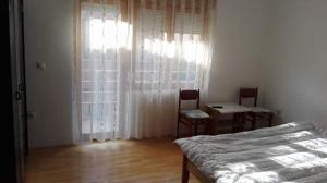 a bedroom with a bed and a table and chairs at Guest House - Apartment Kozle in Skopje
