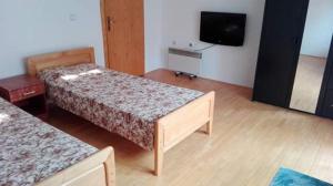 a room with two beds and a flat screen tv at Guest House - Apartment Kozle in Skopje