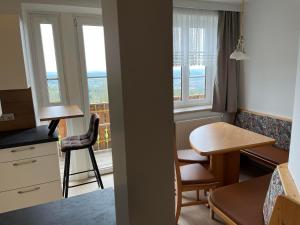 Habitación pequeña con cocina, mesa y escritorio. en Wohlfühl Hotel Wiesenhof, en Grafendorf bei Hartberg