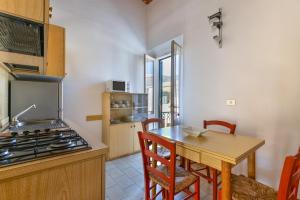 a kitchen with a table and a stove top oven at Il Quadrifoglio 2 in Procchio