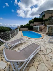 un patio con 2 sedie a sdraio e una piscina di Hôtel Villa Les Orangers a Olmeto