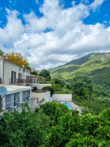 a view of the house and the mountains at Hôtel Villa Les Orangers in Olmeto