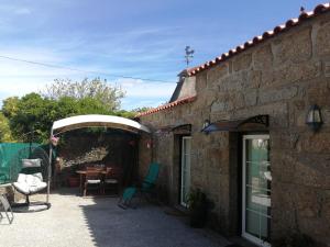 a patio with a table and chairs and a building at Casa Rústica com Piscina Privada - Perto do Porto in Landim +39 photos
