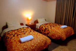 una camera d'albergo con due letti e asciugamani di Hatun Wasi Huaraz a Huaraz