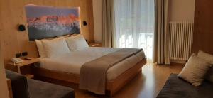 a hotel room with a bed and a couch at Hotel Garni Arnica in Molveno