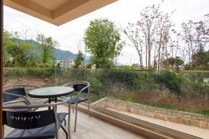 a balcony with a table and chairs and a large window at Cozy one bedroom apartment in Tivat