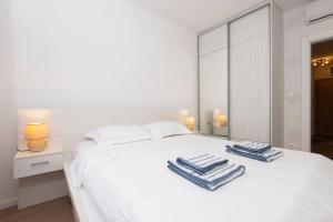 a bedroom with a white bed with towels on it at Cozy one bedroom apartment in Tivat