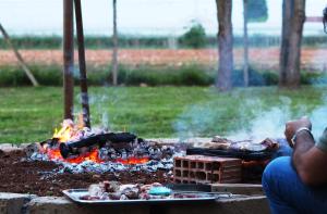 a man sitting in front of a camp fire at Del Falco AgriCamp-12 kilometers to Garda Lake and Verona in Bussolengo