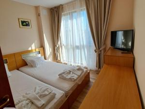a hotel room with two beds and a flat screen tv at Hotel Seasons 3 in Sunny Beach +59 photos