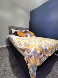 a bedroom with a bed with a colorful comforter at Elite Accomm Wolverhampton sleeps 4 long term workers or family comfortably in Shareshill