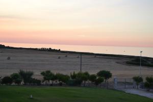a field at sunset with bales of hay at Calanca Apulian Residence in Torre Santa Sabina