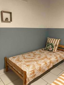 una cama sentada contra una pared en una habitación en Maison avec spa et jardin en Schœlcher