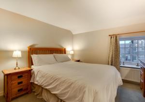 Un dormitorio con una cama grande y una ventana en Barn Owl Cottage, en Masham
