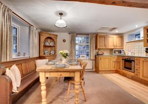 cocina con mesa de madera en una habitación en Barn Owl Cottage, en Masham